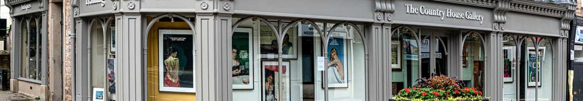 Decorative photo of newly painted shop front with a grey exterior on a sunny day.