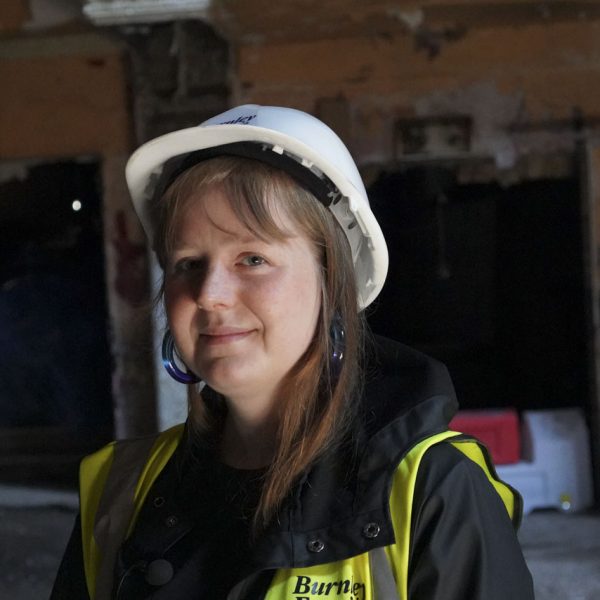 Sophie Gibson - Interview picture for The empire Theatre in Burnley. Sophie is wearing a white hard hat and yellow High visibility vest.
