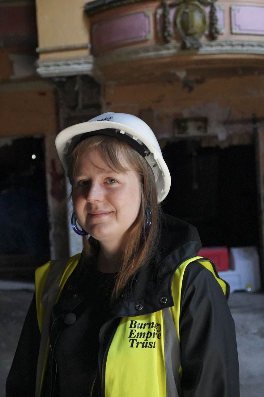 Sophie Gibson - Interview picture for The empire Theatre in Burnley. Sophie is wearing a white hard hat and yellow High visibility vest.